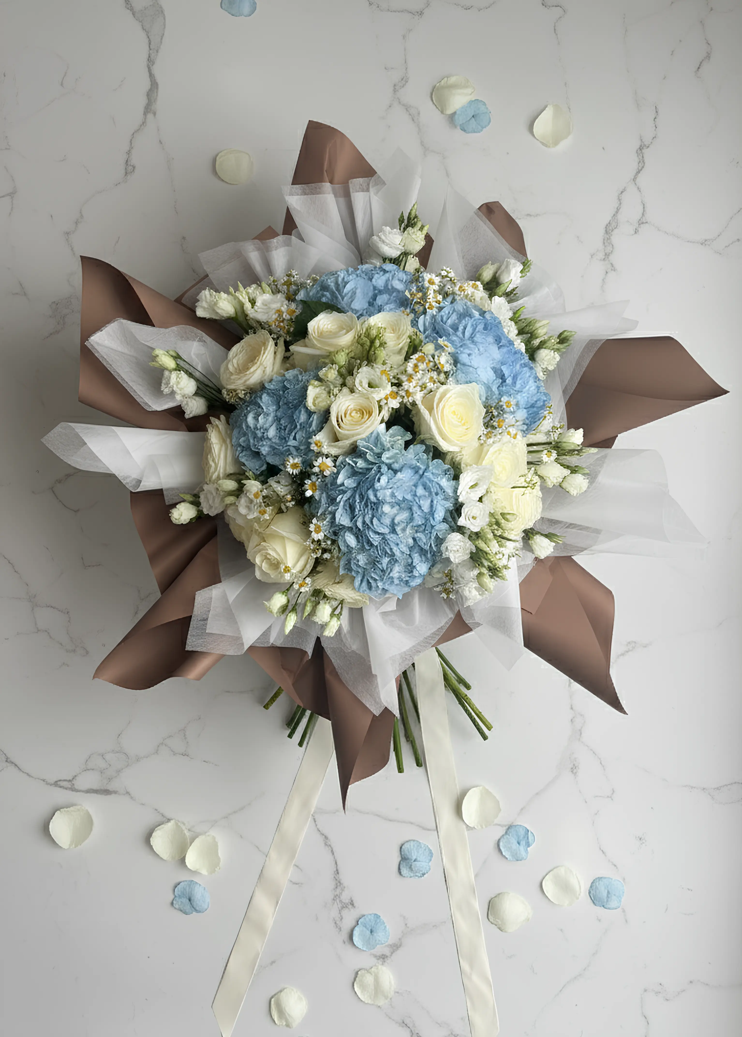 Composition florale naissance hortensia bleu lisianthus camomille