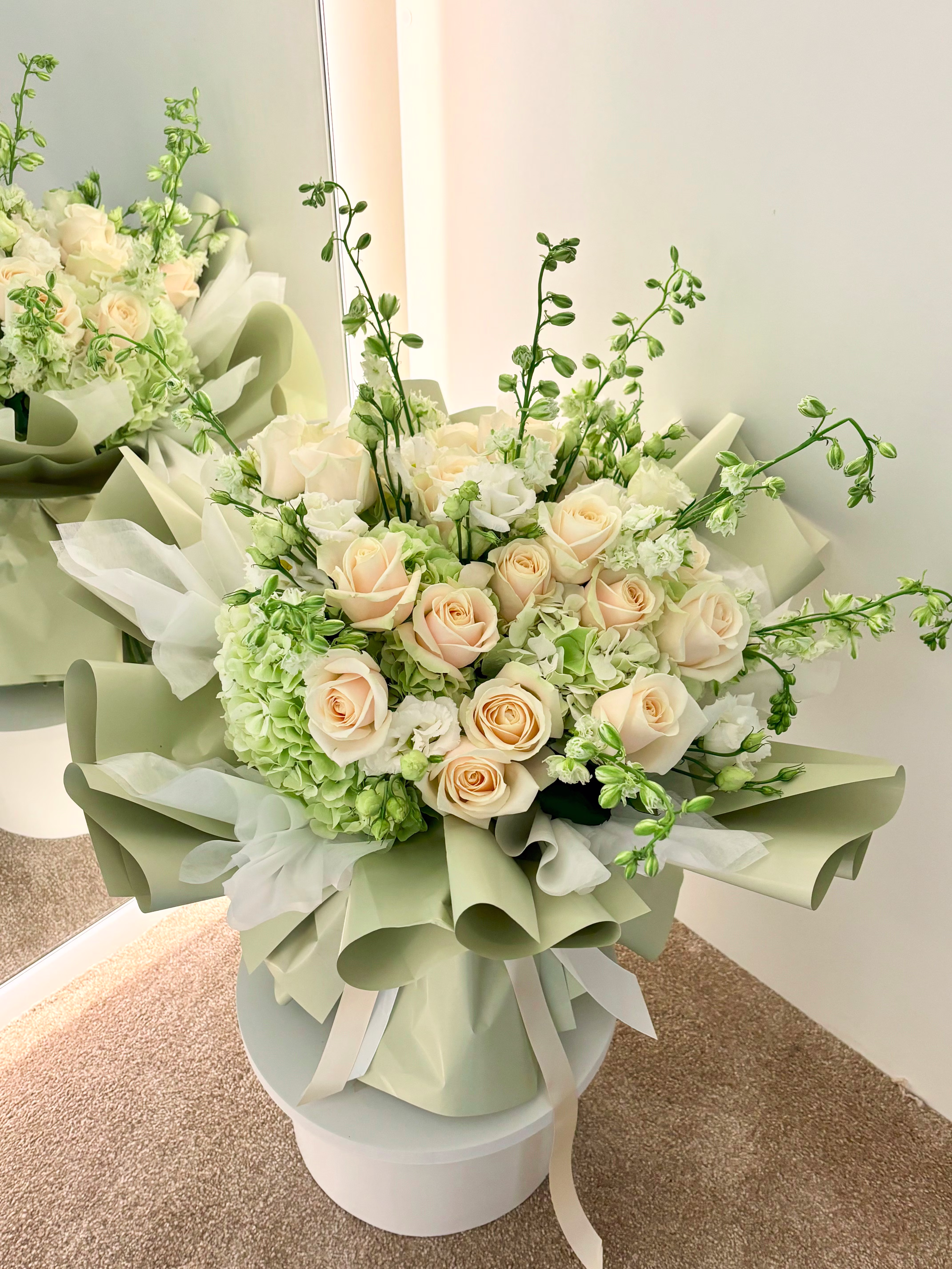 Portrait du bouquet Sauge, hortensias verts et fleurs blanches en papier luxueux couleur sauge, rendu élégant et naturel.